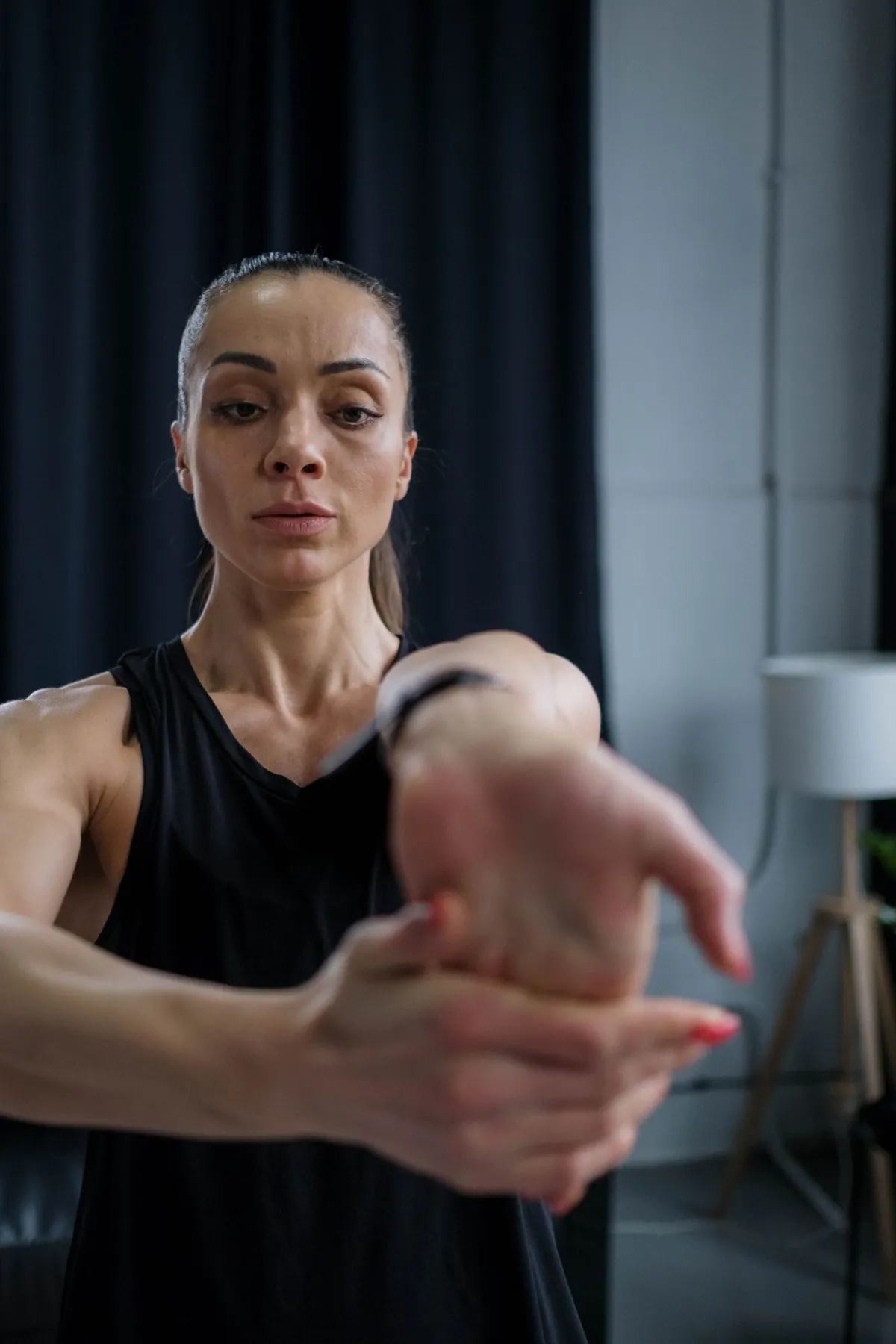 Žena ispruženom rukom isteže pregibače šake drugom rukom